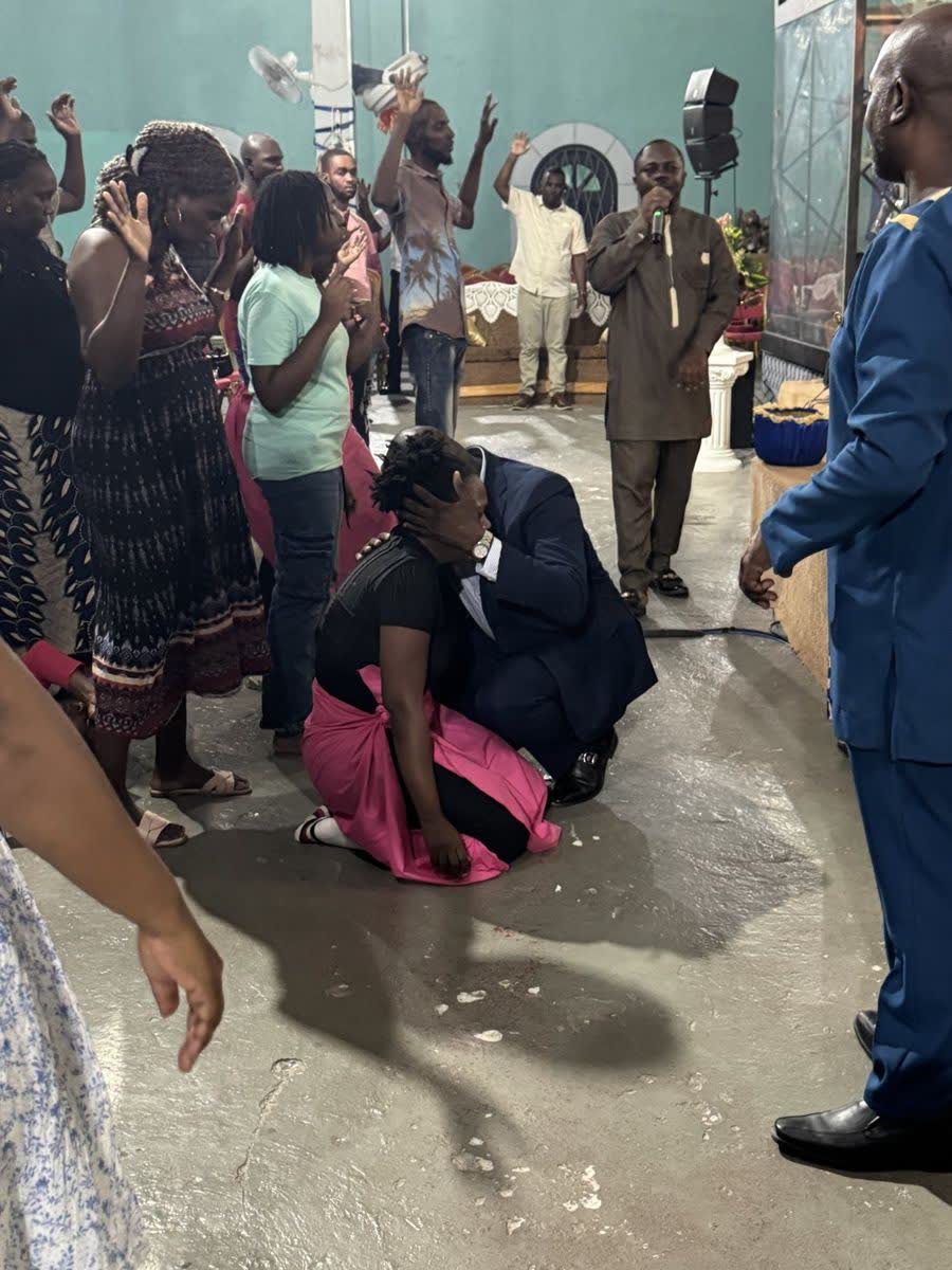 Apostle Lambert ministering to a woman at the altar